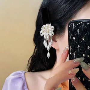 Elegant French style pearl flower hair clip with tassel, worn by model for hair styling