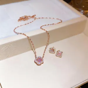 Detailed view of rose gold flower necklace and square sugar-shaped pink zircon stud earrings