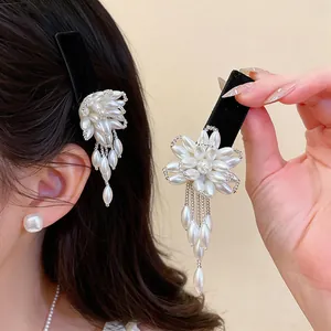 Detail showing the intricate flower design and pearl tassels of the French hair clip