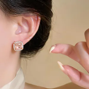 Close-up of elegant square champagne zircon stud earring on ear with rose gold finish