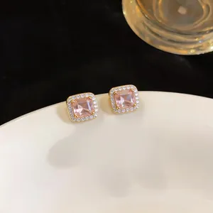 Detailed close-up showing pink square cubic zirconia stud earrings in a luxury gold setting