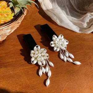 Close-up of French style flower pearl hair clips with velvet base and tassels.