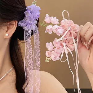 Barrette fleur de muguet violette élégante avec pompon en dentelle et petits strass brillants.