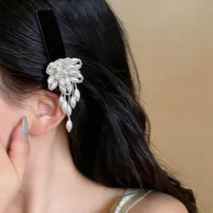 Close-up of elegant flower pearl tassel hair clip worn on long black hair