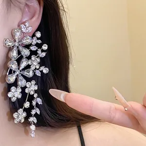 Pendientes largos de flores plateadas con cristales brillantes para ropa de noche elegante.
