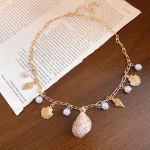 Dettaglio della collana a tema spiaggia con perle e pendente centrale a conchiglia