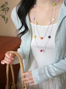Close-up of elegant double-layered necklace with colorful resin flower beads on model