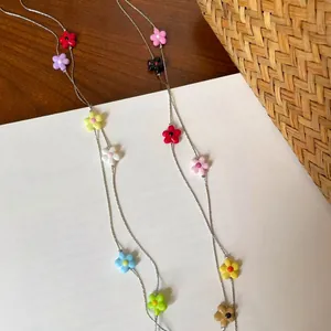 Detailed macro view of vibrant colorful resin flower beads on a slim silver-tone chain
