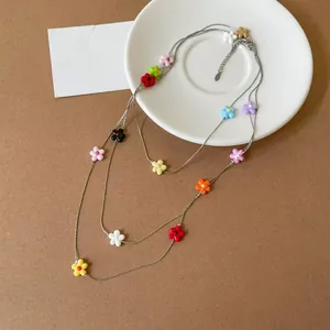 Macro detail of a triple-layered fashion necklace with colorful resin flower beads decoration