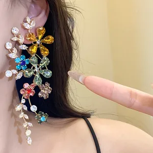 Detalle de primer plano de pendientes colgantes de flores de cristal de colores en la oreja