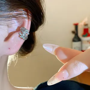 Vista dettagliata di un ear cuff a spiga di grano con zirconi indossato su un orecchio