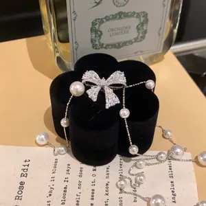 Gros plan d'un élégant collier de perles à nœud en zircon sur velours noir