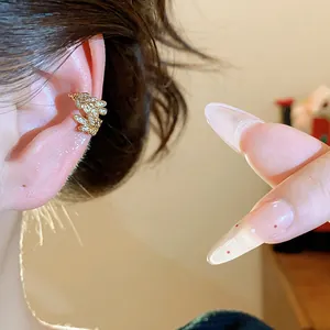 Primo piano dettagliato di un earcuff a forma di spiga di grano in zircone sull'orecchio