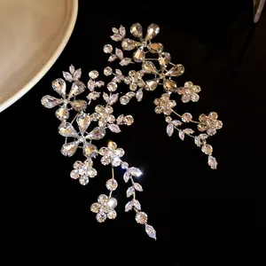 Primer plano de pendientes largos de flores de cristal con pedrería brillante.