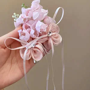 Vue détaillée d'une élégante pince à cheveux muguet avec strass et glands en ruban