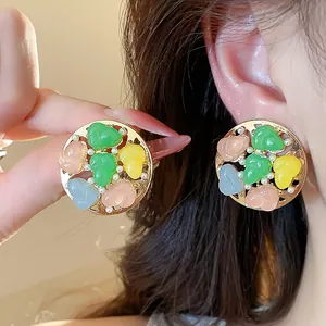 Detailed view of summer style colorful resin and pearl round stud earrings with gold finish