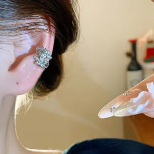 Primo piano di un ear cuff a forma di spiga di grano con zirconi, senza buco