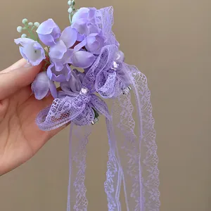 Détail d'une pince à cheveux muguet violet avec glands en dentelle et des strass