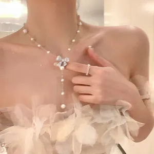 Détail d'un élégant collier avec nœud en zircon et perles blanches sur un mannequin