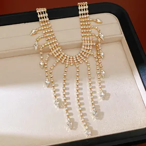 Close-up view of elegant gold tassel necklace with sparkling teardrop rhinestone details