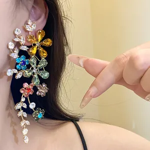 Primer plano de pendientes de flores con cristales de colores y detalles calados.