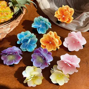 Detailansicht farbenfroher Stoffblumen-Haarspangen in verschiedenen Farben auf Holzoberfläche