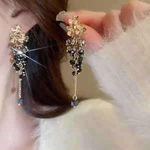 Elegant ethnic style tassel earrings with dark grey faceted beads and golden flower