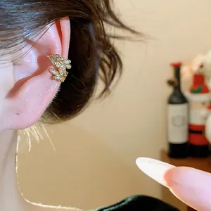 Dettaglio ravvicinato di un polsino per orecchie in zircone a forma di spiga