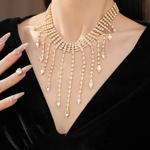 Close-up of elegant gold rhinestone tassel necklace with teardrop crystal pendants.