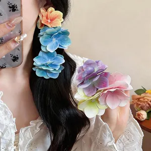 Detailaufnahme eleganter Haarspangen mit Stoffblumen im Farbverlauf im Haar