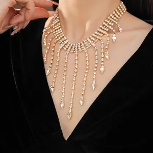 Close-up of elegant gold rhinestone water-drop tassel necklace on a black velvet dress
