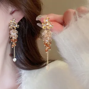 Elegant silver needle long tassel earrings featuring amber beads and golden floral accents