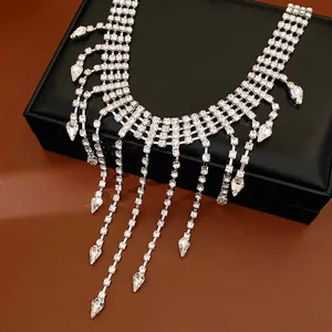 Detail of elegant silver rhinestone necklace with dangling teardrop tassels on black box
