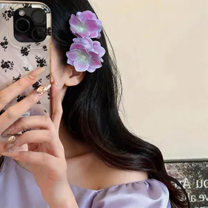 Detailansicht eleganter lila Stoffblumen-Haarspangen, die von einem Model getragen werden