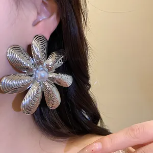Dettaglio ravvicinato di orecchini a fiore d'argento con perla centrale lucida