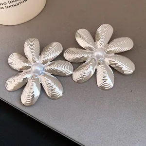 Vista dettagliata di orecchini a fiore in argento testurizzato con perla centrale
