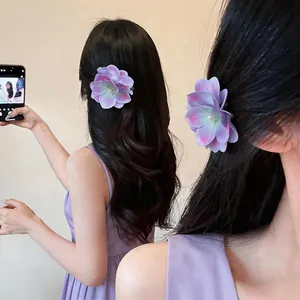 Detailansicht einer lila Stoffblumen-Haarklammer, getragen von einem Model im süßen Stil.