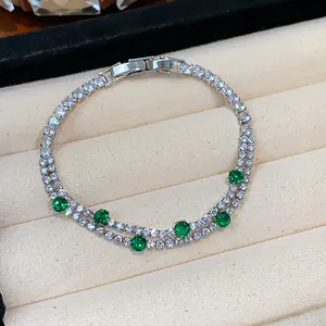 Close-up of elegant double-strand bracelet with green and white cubic zirconia stones.