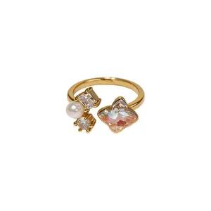 Elegant gold-tone open ring featuring a white pearl and iridescent flower zircon detail