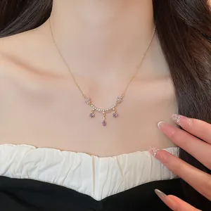 Close-up of 18k gold plated necklace featuring purple zircon flower and teardrop pendants.