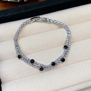 Close-up of double-strand tennis bracelet with black and clear cubic zirconia stones.