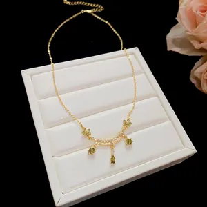 Detail view of 18k gold plated necklace with green zircon flower and waterdrop pendants