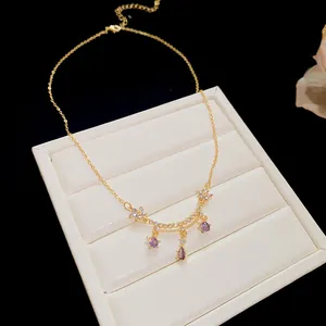 Close-up of 18k gold plated necklace with purple zircon flower and drop pendant