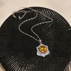 Detailed view of vintage court style necklace with yellow zircon pendant on black plate