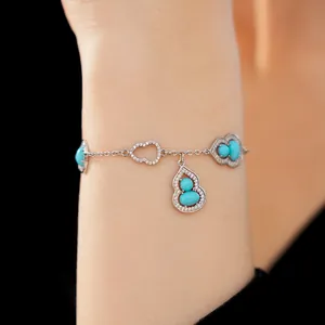 Detailed macro view of 18K gold-plated bracelet with turquoise gourd pendants