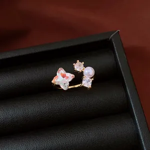Detailed macro shot of a gold-plated open ring featuring zircon and pearl in a jewelry box