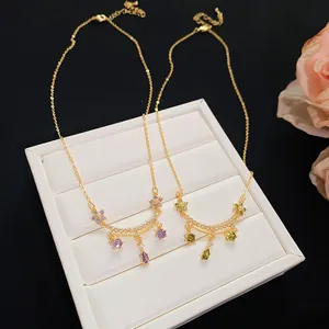 Detailed close-up showing the 18k gold plated flower and teardrop zircon necklaces