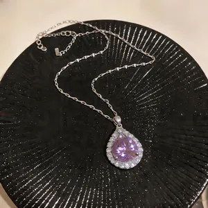 Close-up of retro palace style teardrop necklace with purple zircon pendant.