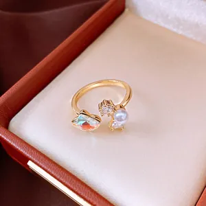 Detailed view of an elegant gold open ring with a shimmering pearl and marquise zircon crystal