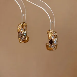 Detailed view of gold honeycomb hoop earrings with sparkling zirconia stones.
